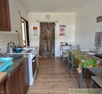 Küche in einer 2-Zimmer-Wohnung mit Herd, Spüle und Boden mit Holzdekor.