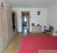 Ein Zimmer in einer 2-Zimmer-Wohnung mit einem Bett, einem Boden in Holzoptik und einem Schrank.