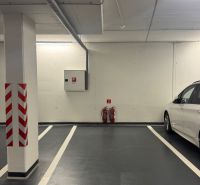 Unterirdischer Parkplatz mit deutlicher Markierung und weißem Auto daneben.