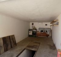 Garage mit Regalen, Straßenboden, Regalen und gelagerten Gegenständen.