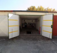 Offene Garage in der Petőfi-Reihe in Štúrovo mit Grube und gelagerten Gegenständen.