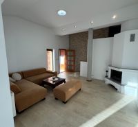 Wohnzimmer in einem Einfamilienhaus mit Kamin und geräumiger Sitzgarnitur.