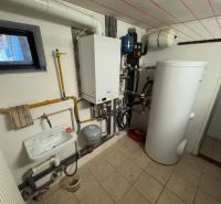 Technikraum mit Heizkörper, Waschbecken und Boiler in einem Einfamilienhaus.