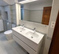 Badezimmer mit Doppelwaschbecken und großem Spiegel in einem Einfamilienhaus.