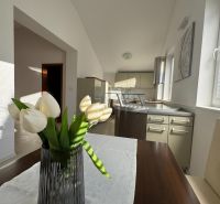Küche in einem Einfamilienhaus mit einer dekorativen Vase und weißen Blumen auf dem Tisch.