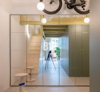 Spiegelwand und Treppe, die in die obere Etage einer 2-Zimmer-Wohnung führen.