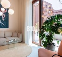 Wohnzimmer in einer 2-Zimmer-Wohnung mit Sofa, Sessel und Zimmerpflanze.