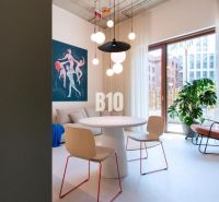 Essbereich in einer 2-Zimmer-Wohnung mit einem Kunstgemälde und Hängelampen.