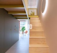 Die Treppe führt in das obere Stockwerk einer 2-Zimmer-Wohnung mit hellem Interieur.