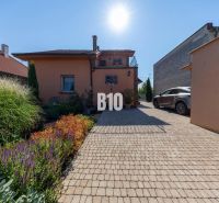 Einfamilienhaus in der Bratislavská-Straße in Malinovo, Garten mit Blumen und geparktes Auto.