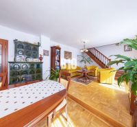 Wohnzimmer in einem Einfamilienhaus mit Holzboden, einem Ofen und einer Holztreppe.