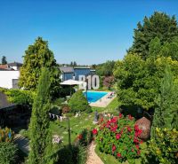 Der Garten des Einfamilienhauses in der Bratislavská Straße in Malinovo mit Pool und Grünflächen.