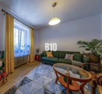 Wohnzimmer in einem Einfamilienhaus mit Sofa, Teppich und Holzboden.