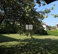 Ein Einfamilienhaus in Žilina mit Garten, Obstbaum und Rasen.
