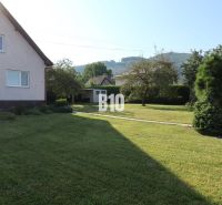 Ein Einfamilienhaus in Žilina mit einem gepflegten Garten und Blick auf die umliegenden Hügel.