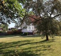 Ein Einfamilienhaus in Žilina mit einem großen Garten, Rasen und Obstbäumen.