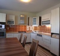 Küche in einem Einfamilienhaus mit Holzdekor und Geräten, mit geräumigem Esstisch.
