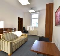 Büros mit gestreiftem Sofa, Tisch und Regal, einfaches Interieur.