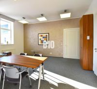 Ein Bürointerieur mit Teppichboden, Tisch, Stühlen und einem Wandbild.