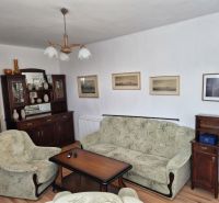 Wohnzimmer eines Einfamilienhauses mit Sesseln, Sofa und Möbelwand.