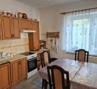 Eine Küche in einem Einfamilienhaus mit Holzdekor, Küchenzeile, Esstisch und Dekorationen.