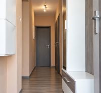 Ein Flur in einem Einfamilienhaus mit einem Holzboden und hellen Wänden.