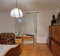 Ein Zimmer in einem Einfamilienhaus mit einem Einzelbett und einem Boden in Holzoptik.