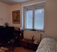 Ein Zimmer in einem Einfamilienhaus mit einem Bett, einem Fernseher und einer Kommode.