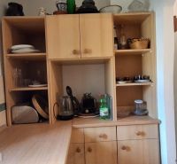 Küchenschrank in einem Einfamilienhaus mit flachen Regalen und einem weißen Kühlschrank.