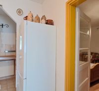Küche in einem Einfamilienhaus mit Kühlschrank, Ziegeldekor und Holzmöbeln.