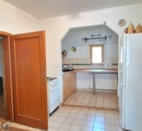 Eine Küche in einem Einfamilienhaus mit Keramikboden, einem Gasherd und einem weißen Kühlschrank.