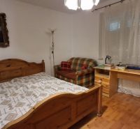 Schlafzimmer in einem Einfamilienhaus mit Holzelementen, Bett und Schreibtisch.
