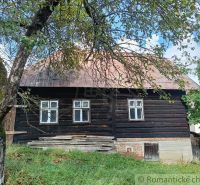 Rustikales Ferienhaus in Staškov, umgeben von Grün und blauem Himmel.