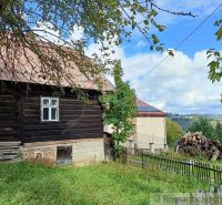 Holzhütte in Staškov mit Obstbäumen und Blick auf die umliegende Landschaft.