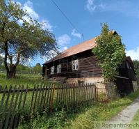 Eine Holzhütte in Staškov, umgeben von Grün und einem Zaun.