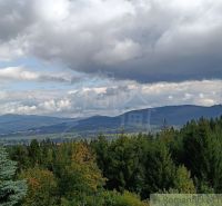 Blick von der Hütte in Staškov auf die hügelige Landschaft unter einem bewölkten Himmel.