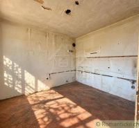 Ein verlassenes Zimmer in einem Einfamilienhaus mit einem Boden in Ziegeldekor.