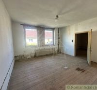 Ein Zimmer in einem Einfamilienhaus mit einem Holzboden-Dekor benötigt eine Renovierung.