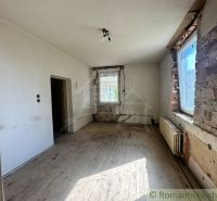Ein abgenutzter Raum mit einem Holzboden, der auf eine Renovierung in einem Einfamilienhaus wartet.