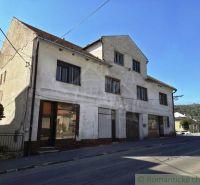 Das Äußere des Gebäudes in Modrý Kameň mit Geschäftsräumen, neben der Straße und der Natur.