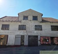 Geschäftsräume in Modrý Kameň mit abgenutzter Fassade und Schrägdach.