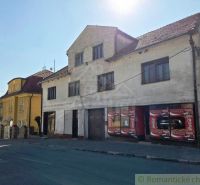 Ein Gebäude mit Geschäftsräumen in der Stadt Modrý Kameň, sichtbar über die Straße.
