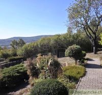 Eine Hütte in Modrý Kameň mit einem gepflegten Garten und Blick auf die hügelige Landschaft.