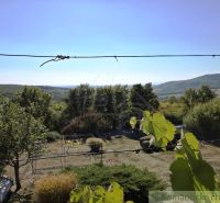 Der Blick von der Hütte in Modrý Kameň, umgeben von Grün und Hügeln im Hintergrund.