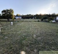 Gärten in Krupina, Häuser am Hang, Gras und Bäume, man sieht einen Verteilerkasten.