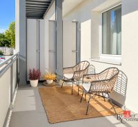 Ein Balkon in der Alexandra-Matušku-Straße in Banská Bystrica mit Rattanstühlen und Teppich.