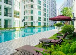 Pattaya, Bau von Wohnungen mit Pool, Liegestühlen und Sonnenschirmen in einem Wohngebiet.