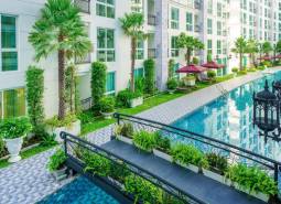 Wohnungsbau in Pattaya mit Pool, Grünflächen, Balkonen und Außenbereichen zur Entspannung.