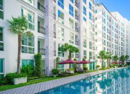 Wohnungsbau in Pattaya: Weißer Wohnkomplex mit Palmen und Pool.