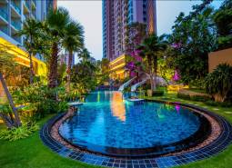 Ein Pool mit Grünflächen beim Bau von Wohnungen in Pattaya.